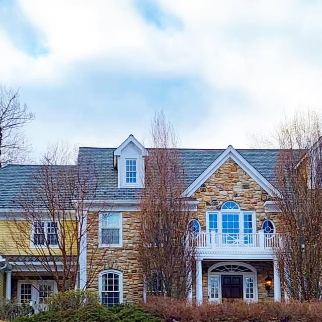 Large stone-front home with completed roofline details